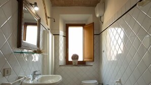 A bathroom with a checkered floor, a sink, a toilet, and a bidet. - Agritiurismo San Carlo-Family apartment - 3 bedrooms with San Carlo Quadri pool (pomarance)