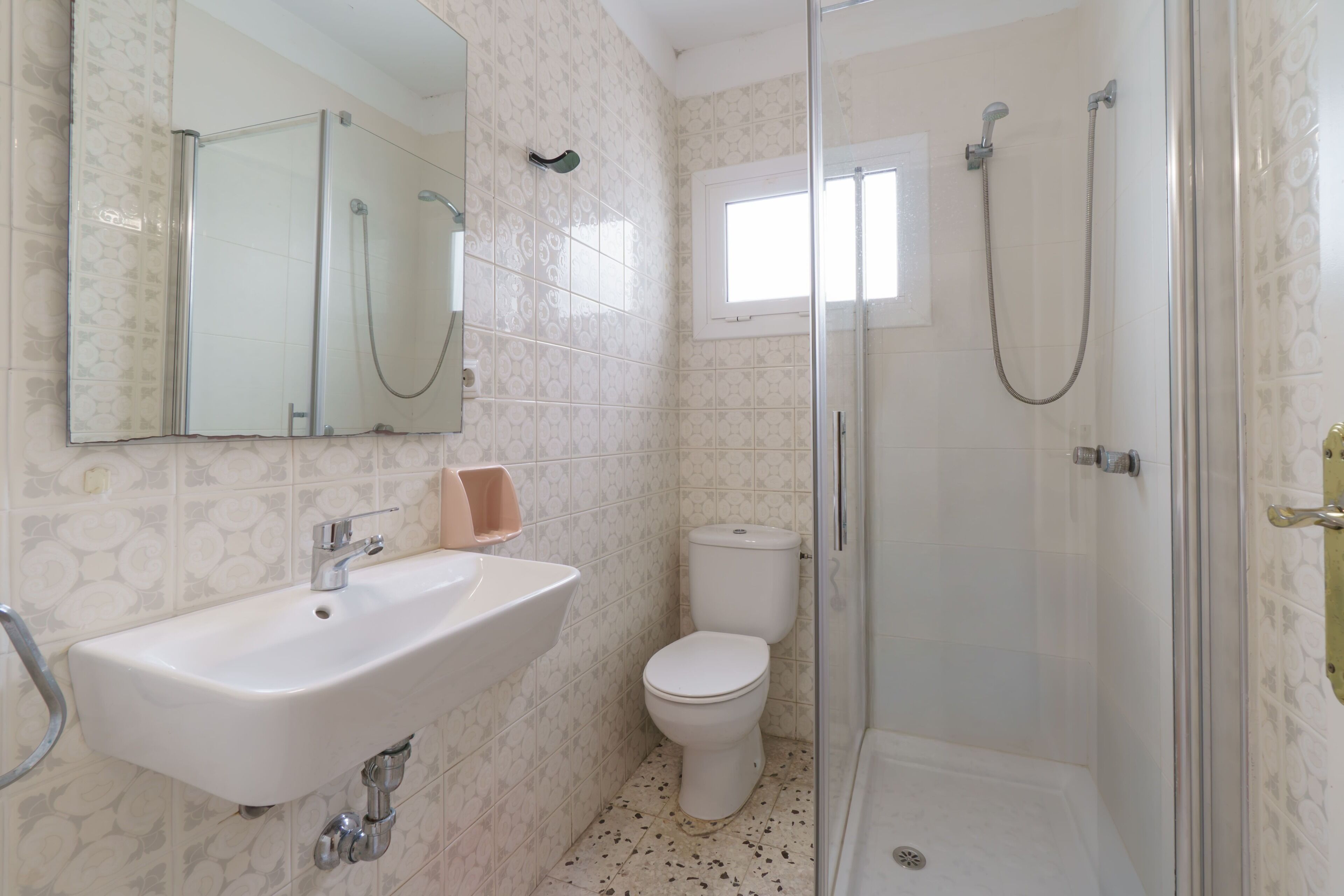 Une salle de bain équipée d’un lavabo, de toilettes et d’une douche à parois de verre.