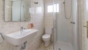 Casa de banho com lavatório, sanita e cabine de duche.