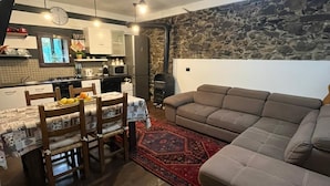 Un salon confortable avec un canapé et un coin repas comprenant une table et des chaises.