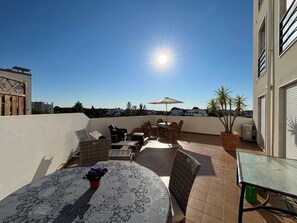 A rooftop terrace with a table, chairs, and a potted plant. - 3 bedrooms, 50 m2 private terrace, air conditioned all rooms, renovated 2022 (Tavira)