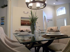 Enjoy meals with friends and family in this stylish dining area, featuring a glass-top table and comfortable seating for four.