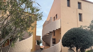 A stone pathway leading to a building with a spiral staircase and a small garden area. - Apartment/ flat - Collioure (Collioure)
