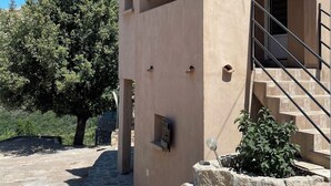 A small, single-story building with a tiled roof and a stone staircase leading to the entrance. - house / villa - Monacia d'Aullène (Monacia-D'aullène)