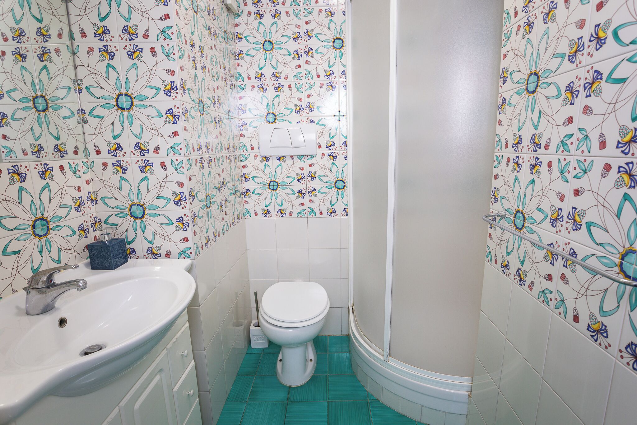 Un baño con un lavabo blanco, un inodoro y una zona de ducha.