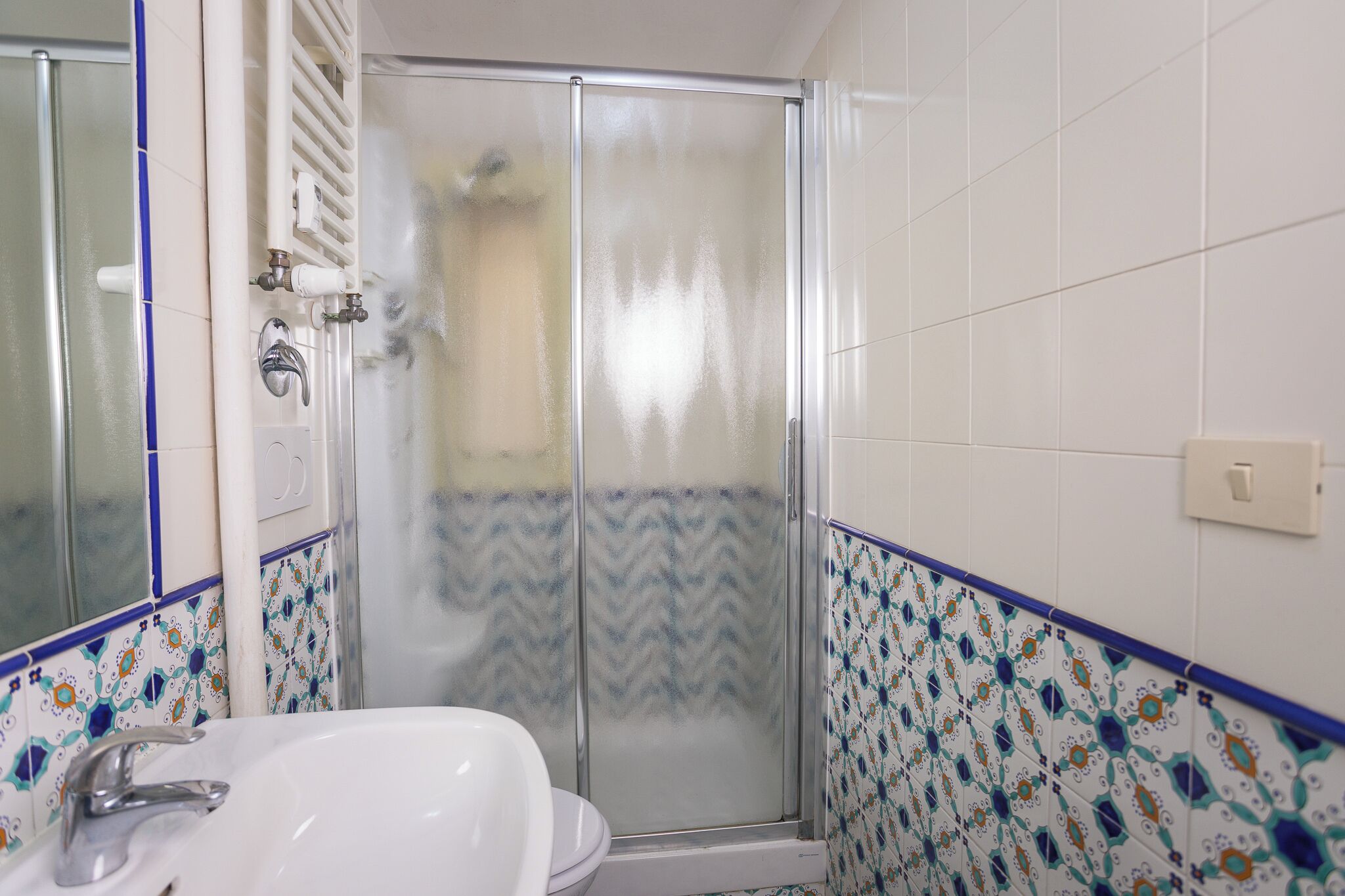 A bathroom with a shower, toilet, and sink.