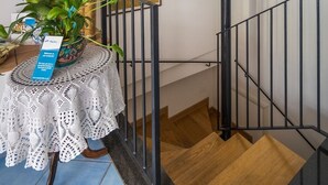 A staircase with a stone wall, a wooden handrail, and a metal railing. - Domus Le Postali, Lovely 2 bedroom beach apartment on Sorrento Coast (Vico Equense)