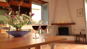 A dining table with a vase of flowers and two wine glasses. - Capitorio: quiet rural spot, aromatic garden, great views (Roccalbegna)
