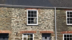 A stone building with two windows and a door, a chimney, and a clear sky. - Stylish Cottage, central location with harbour view and double parking (Salcombe)