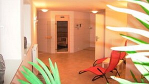 A hallway with a red chair, a door, and a plant.