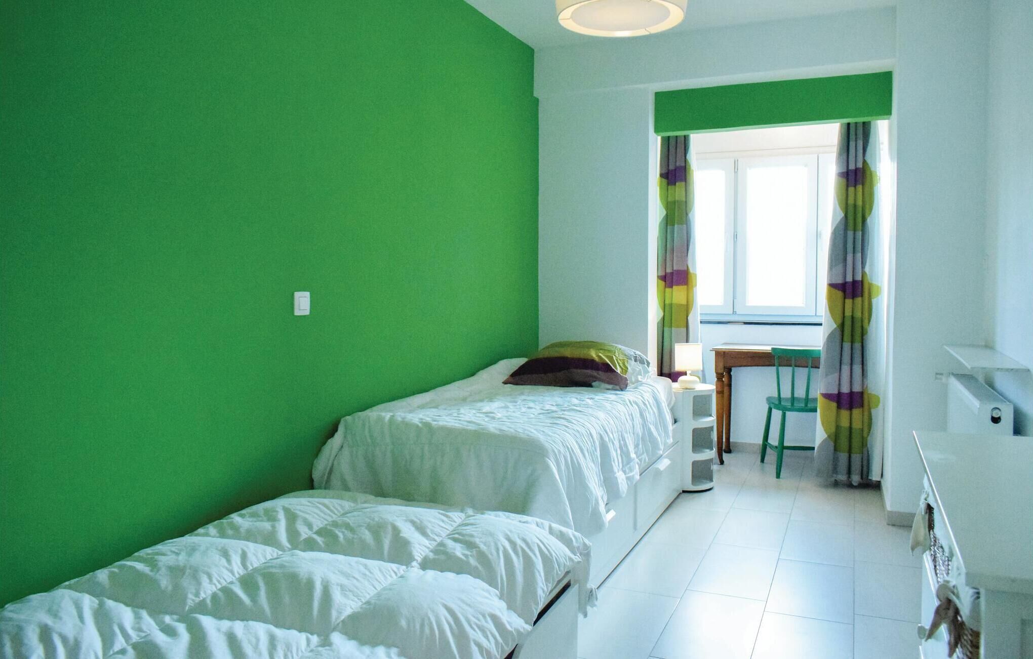 A room with two beds, a desk, and a chair.