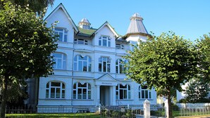 A large, white, multi-story building with a prominent entrance and two towers.