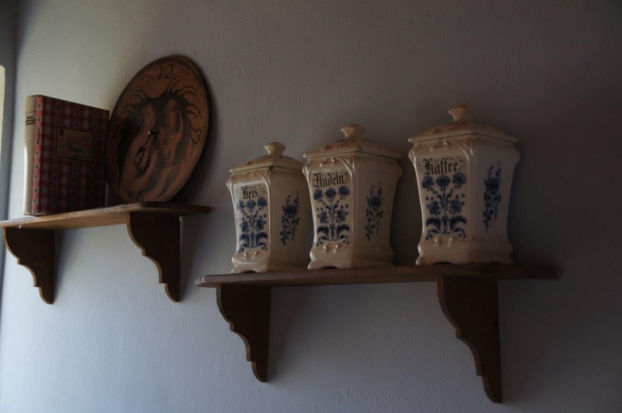 A shelf with three ceramic containers labeled 'Butter' and a book.