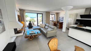 A modern living room with a sofa, a coffee table, and a dining area with chairs. - Villa Bianca, with its own pool and Wi-Fi, close to the ocean, sheltered courtyard (patio) (Costa Calma)