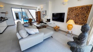 A modern living room with a sofa, TV, and decorative items. - Villa Bianca, with its own pool and Wi-Fi, close to the ocean, sheltered courtyard (patio) (Costa Calma)