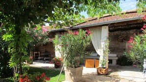 A patio area with potted plants, a stone wall, and a wooden fence. - Character house for 12 people, PRIVATE POOL (Lussas)