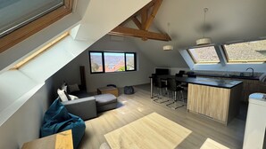 Ein modernes Loft mit Küche, Essbereich und Sitzgelegenheit.