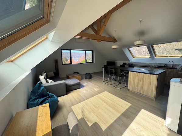 A modern loft with a kitchen, dining area, and seating space.