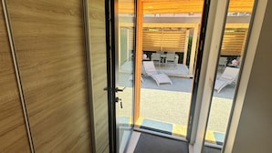 Ein modernes Interieur mit einer Schiebeglastür, die auf eine Terrasse im Freien führt.