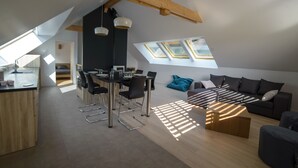 Ein modernes Loft mit Essbereich, einer Sofagruppe und Dachfenstern.