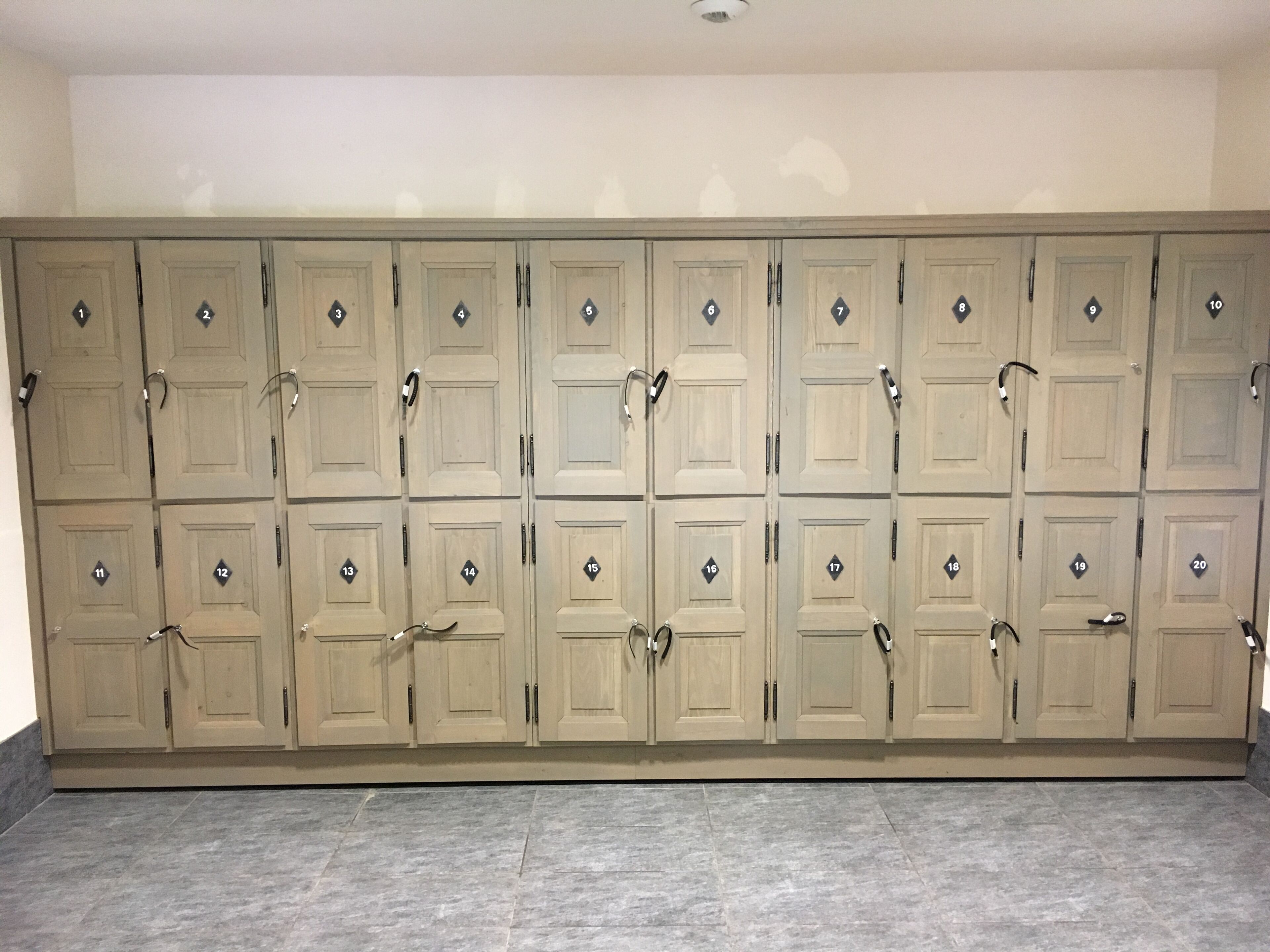 Een rij beige dubbele deuren, genummerd van 1 tot 20, waarschijnlijk hotelkamer nummers.
