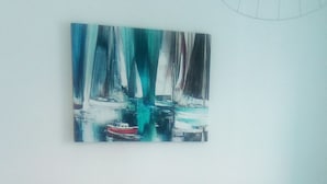 Un lit avec une tête de lit, deux oreillers et un tableau accroché au-dessus.