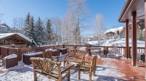 A wooden deck with outdoor seating, snow on the ground, and a building in the background. - Shirana #1: Great location and large gathering space! Steps to skiing & gondola (Mountain Village)