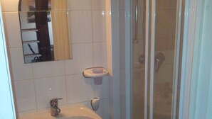A bathroom with a sink, mirror, and shower. - Studio in Trouville sur Mer (Trouville-sur-Mer)