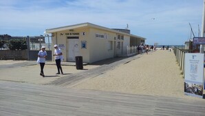 Een gebouw aan het strand met een bord waarop 'CLUB DE PLONGEE' staat en een 'POSTE DE SECOUIL' voor omkleden.
