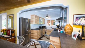 Una cocina moderna con armarios de madera, electrodomésticos de acero inoxidable y suelo de mármol.
