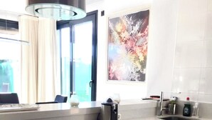 Une cuisine moderne dotée d’un grand îlot central, d’appareils électroménagers en acier inoxydable et de meubles de rangement en bois.
