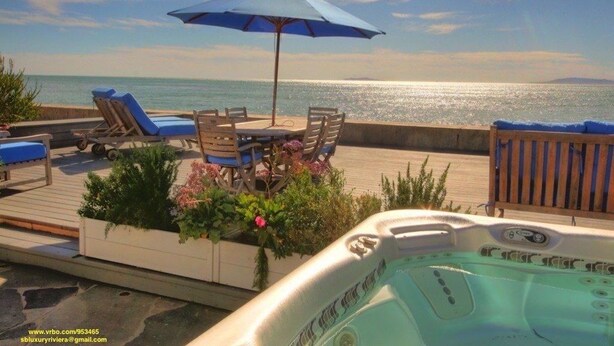 Zona junto a la piscina con sillones de descanso, una bañera de hidromasaje y vistas al océano.