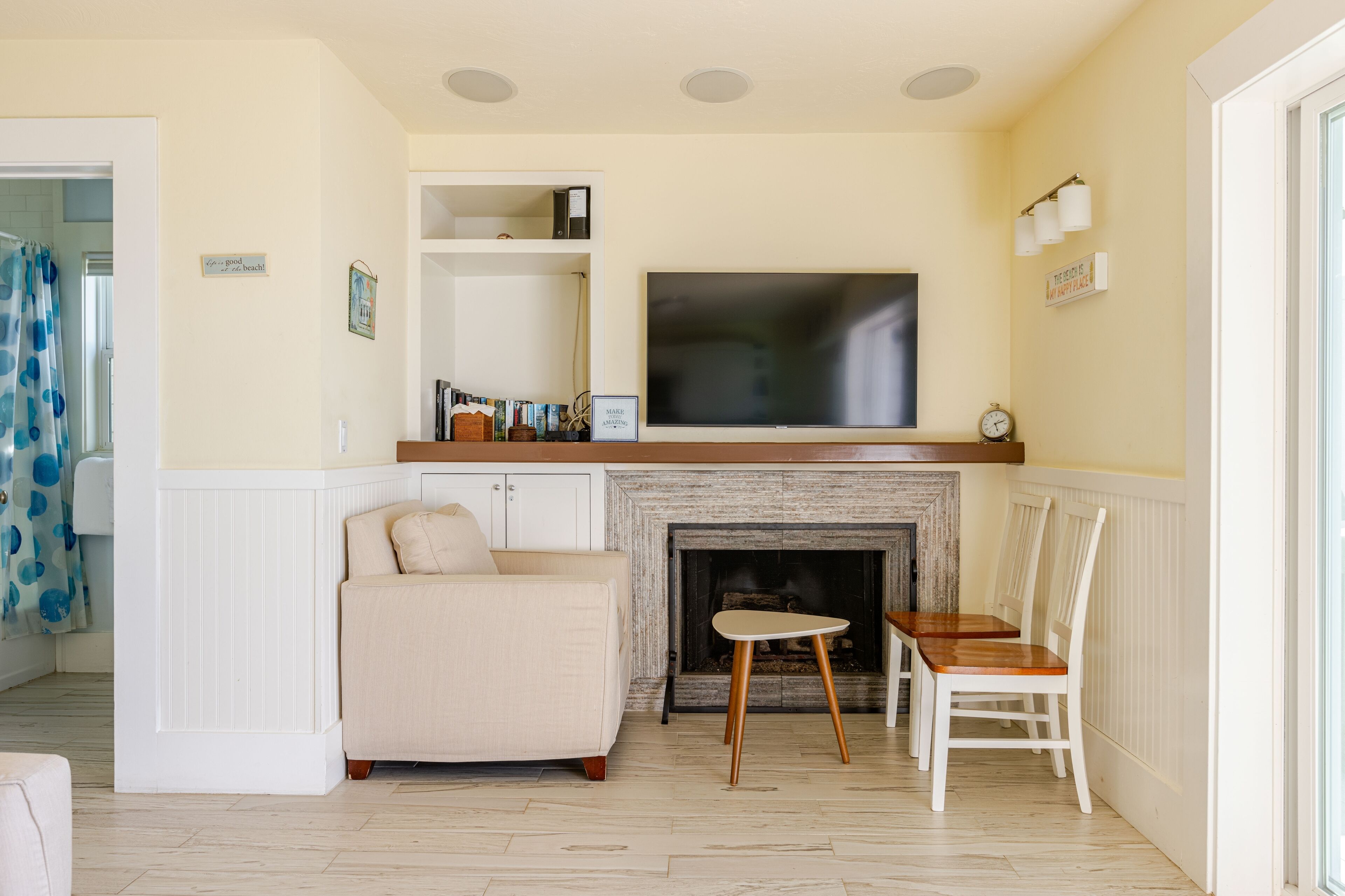 A living room with a fireplace, a television, a sofa, and a dining table with chairs.