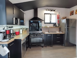 Une cuisine moderne équipée d’une cuisinière, d’un four, d’un four à micro-ondes et d’un réfrigérateur.