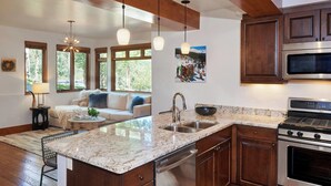 A modern kitchen with granite countertops, stainless steel appliances, and wooden cabinets. - Mountain-Chic Chalet | Aspenwood #KA | 2B/2B (Snowmass Village)