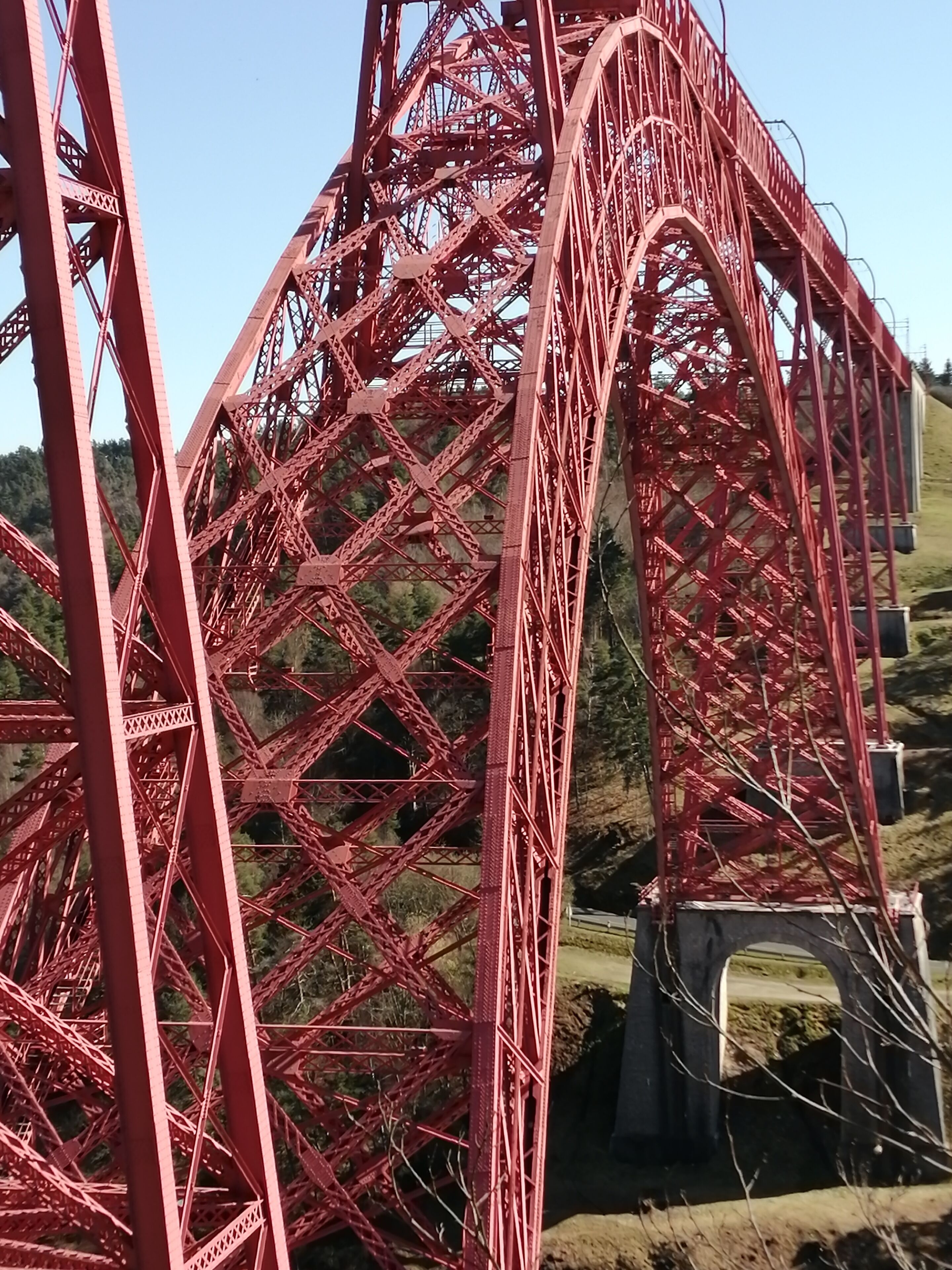 A large red steel bridge structure with complex lattice design.