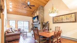A cozy living room with a fireplace, wooden dining table, and comfortable seating. - 3/2 Ski In/Out  BEAVER CREEK, steps to Village, Townsend Place A307 (Beaver Creek)