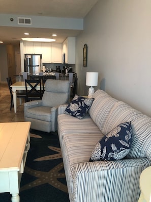 Relax in this inviting living space with a striped sofa, armchair, and dining table.