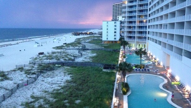 A hotel with a pool area, beach access, and a view of the ocean.