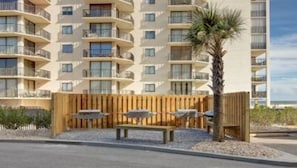 Stylish residential building with balconies and a charming outdoor seating area.