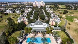 A resort with a central building, a swimming pool, and golf courses.