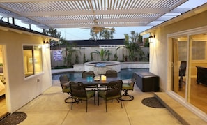 Une terrasse avec une piscine, des sièges d’extérieur et un ventilateur de plafond.
