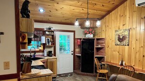 Een houten interieur met een keuken, eethoek en een gezellige zithoek.