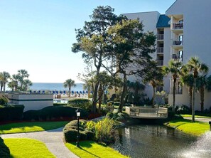 Ein Hotel mit Pool, Palmen und Meerblick.