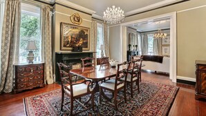 A formal dining room with a wooden table, chairs, and a chandelier.