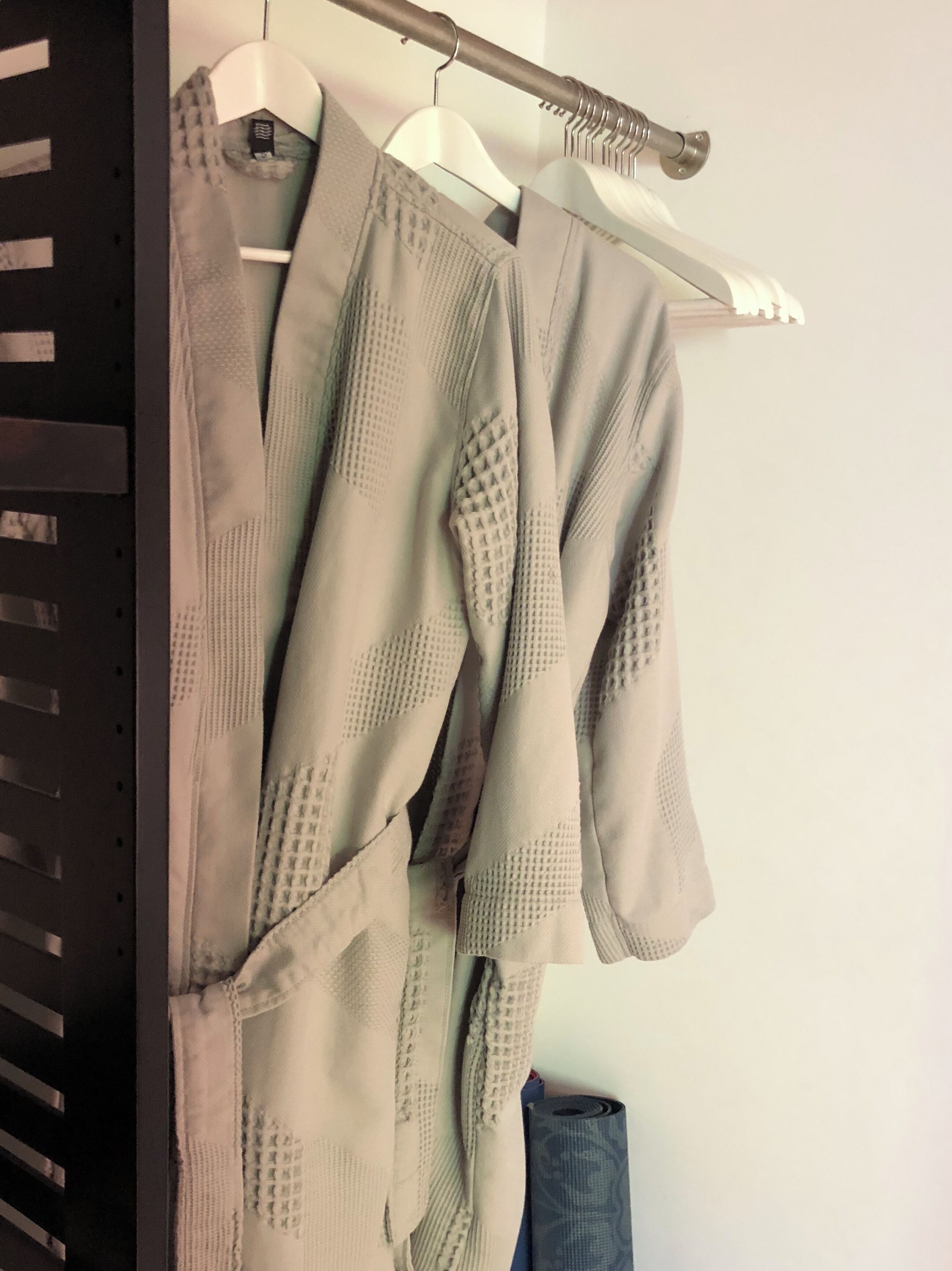 Un appendiabiti con diversi capi di abbigliamento, tra cui una maglia a maniche lunghe e un paio di jeans.