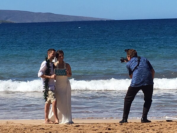 Una ceremonia de boda en la playa, con un fotógrafo inmortalizando el instante.