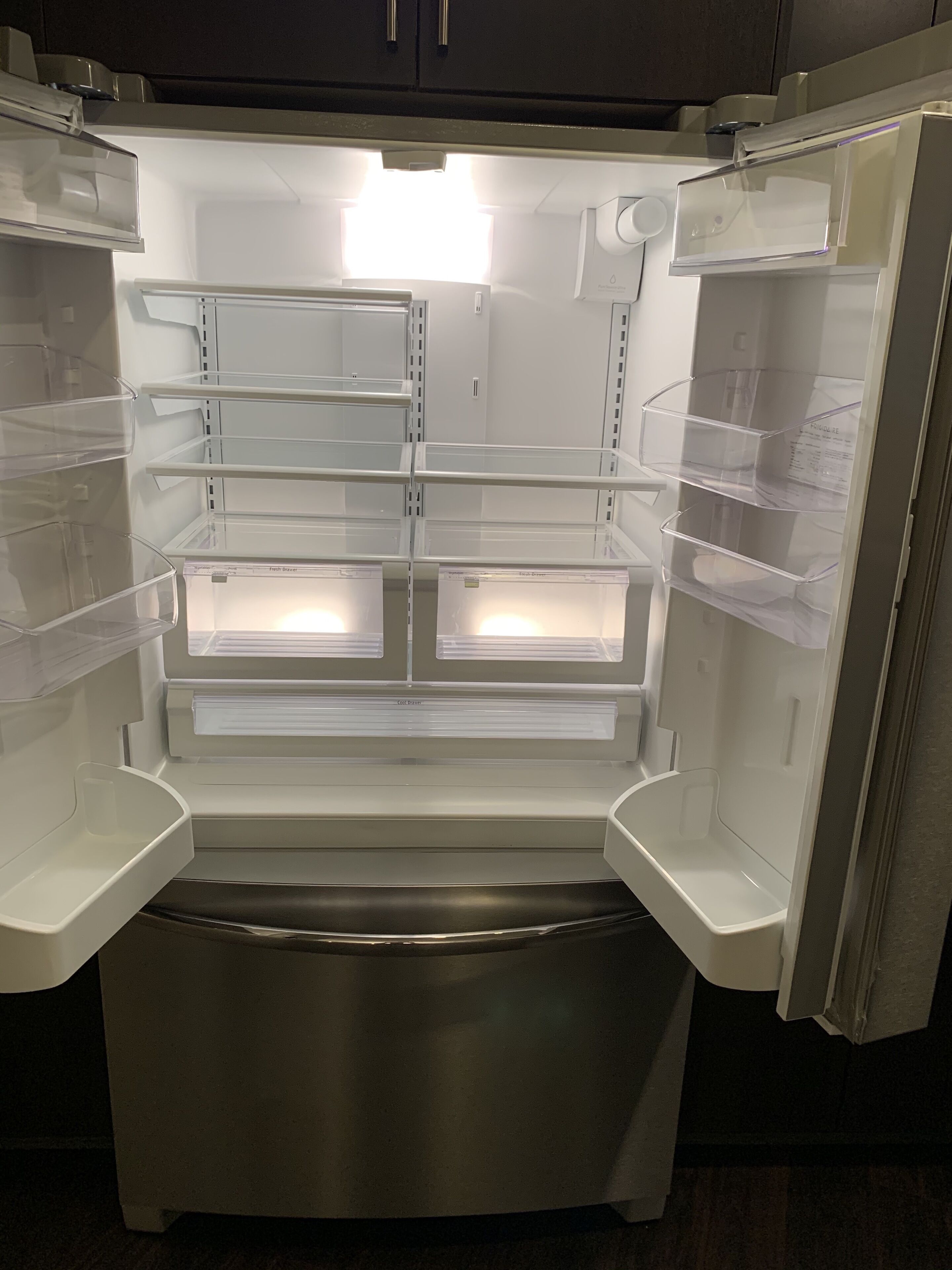 Un refrigerador vacío con varios estantes y un compartimento congelador.