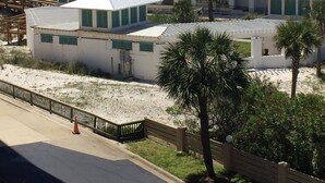 A beachfront property with a large building, multiple beach umbrellas, and a view of the ocean. - Wow!!! Updated Beach Front Resort 3rd Fl Condo with amazing view. (Destin)