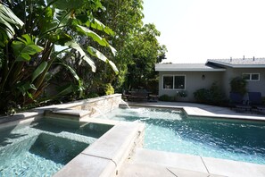 Relax by the serene pool surrounded by lush foliage and comfortable outdoor seating.